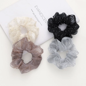 Détails de quatre chouchous en organza scintillants en crème, noir, café et gris avec sequins