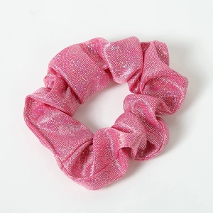 Macro detail of sparkly pink fabric scrunchie with metallic glitter and elastic texture