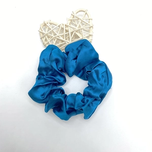 Détail du chouchou en satin bleu roi avec plis souples et texture élégante et brillante