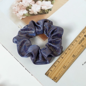 Macro shot of navy blue sequin scrunchie with colorful sparkles and fabric texture