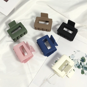 Lot de six pinces à cheveux carrées mates aux couleurs macaron sur un fond de tissu en soie