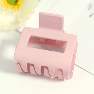 Détail de la pince à cheveux rectangulaire rose mat avec dents intérieures robustes