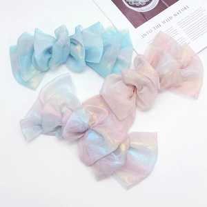 Iridescent oversized chiffon bow hair clips in pastel rainbow colors on a white background