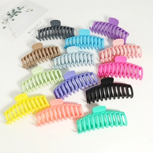 Macro detail of various 14cm matte hair claw clips in assorted colors for hair styling