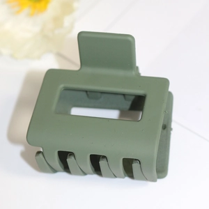 Détail d'une pince à cheveux rectangulaire vert olive mat pour la coiffure