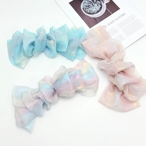 Detail of colorful iridescent chiffon bow hair clips with pastel gradient fabric texture