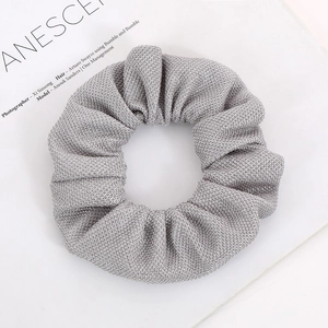 Detailed view of silver mesh scrunchie with elastic corn grain texture on magazine