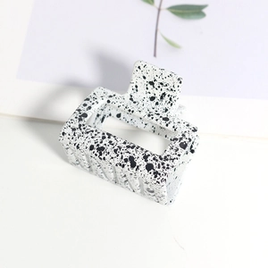 Détail de la pince à cheveux rectangulaire avec motif de taches d'encre noir et blanc