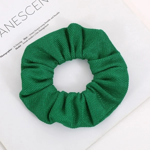 Detail of emerald green knitted scrunchie with corn kernel texture on fashion magazine