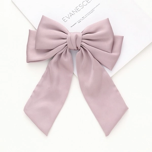 Détail du nœud papillon en satin mat à plusieurs couches avec de longs rubans élégants