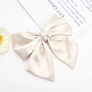Elegant champagne satin bow hair clip with ribbons for women on white background