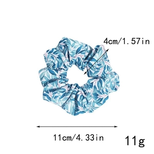 Détail d'un chouchou en tissu fleuri avec motif de feuilles bleues et dimensions