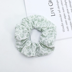 Detail shot of light green quilted floral scrunchie with French style flower pattern