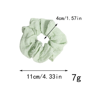 Détail macro d'un chouchou vert clair montrant les mesures de 11 cm de diamètre