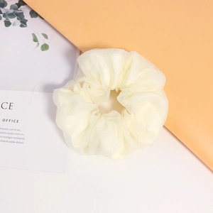 Dettaglio di un elastico per capelli in organza bianco crema con pizzo e pieghe morbide