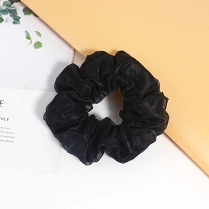 Elegante elastico per capelli in organza nera con doppio strato su sfondo minimalista