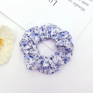 Floral fabric scrunchie with blue and purple flower patterns on a white background