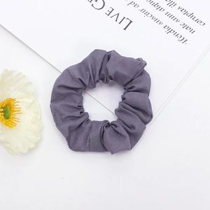 Texture détaillée d'un chouchou en tissu violet avec des plis doux et structure élastique