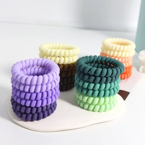 Matte spiral telephone wire hair ties in various colors on a white display tray