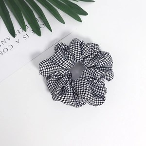 Black and white houndstooth hair scrunchie with elegant pleated fabric design