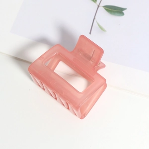 Détail d'une pince à cheveux carrée rose translucide au design géométrique creux