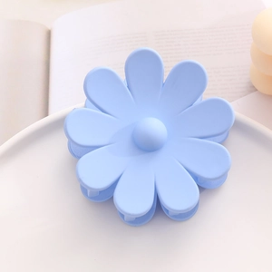 Vue détaillée de la pince à cheveux marguerite bleu clair avec une texture mate