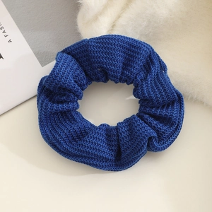 Detailed view of dark blue knitted scrunchie showing hand-woven wool texture and elastic
