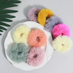 Set di elastici per capelli colorati in finta pelliccia su un vassoio di ceramica