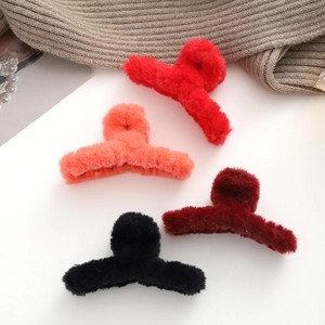 Dettaglio di mollette per capelli in peluche a forma di orso su sfondo in maglia morbida