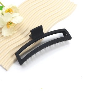 Detail shot of a 14cm large black matte hair claw clip with strong spring on a display board