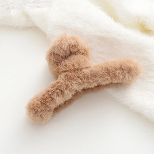 Dettaglio della pinza per capelli in peluche marrone kaki con morbida trama in finta pelliccia
