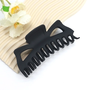 Matte black 14cm large shark hair claw clip with elegant hollow design on display board