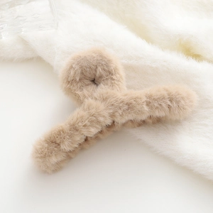 Dettaglio della molletta per capelli in peluche kaki con consistenza soffice e denti a croce