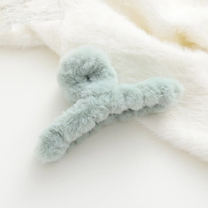 Dettaglio della pinza per capelli verde menta in peluche con morbida texture in ecopelliccia
