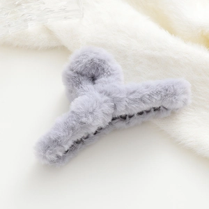 Dettaglio della molletta per capelli in peluche grigio morbido con denti antiscivolo