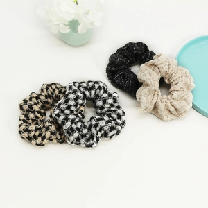 Set of four elegant tweed checkered scrunchies in classic black, white, and beige tones