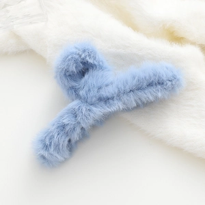 Dettaglio della molletta per capelli in peluche celeste con morbida trama in finta pelliccia