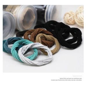 Detail view of multi-color seamless hair ties with spiral texture in a storage jar