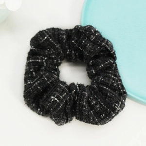 Detail showing classic black tweed scrunchie with metallic silver thread texture