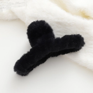 Dettaglio della molletta per capelli in peluche nero con morbida finta pelliccia