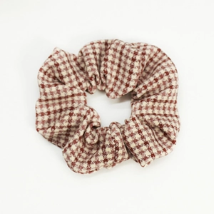 Macro shot of red and white houndstooth pattern scrunchie with soft fabric texture