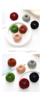 Detailed view of velvet bird nest hair clips in assorted colors on a white tray