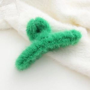 Dettaglio macro della molletta per capelli in peluche verde brillante con soffice pelliccia