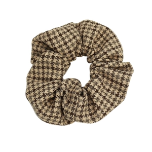 Classic houndstooth fabric scrunchie in brown and beige for elegant ponytail styling