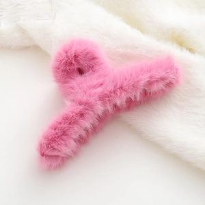 Dettaglio di un fermaglio per capelli in pelliccia sintetica rosa su morbido peluche