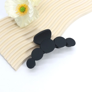 Detail shot of a large matte black hair claw clip with a modern geometric bubble design