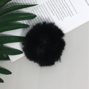 Dettaglio di un morbido elastico per capelli in finta pelliccia nera su fondo moderno