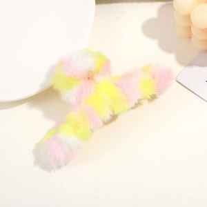 Close-up of fluffy faux fur hair claw clip in soft pink, yellow, and white rainbow tones