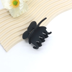 Macro detail of large black matte shark hair claw clip with butterfly shape and metal spring