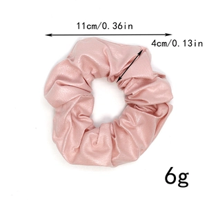 Detailed view of pink PU leather scrunchie with 11cm diameter and metallic texture finish